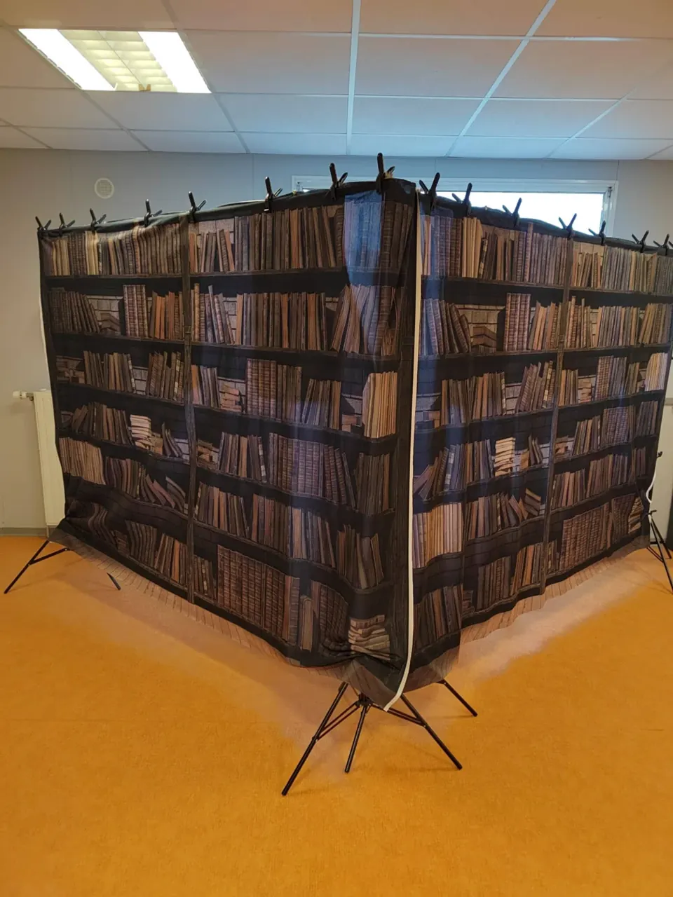 Décor de bibliothèque en paravent installé dans une salle
