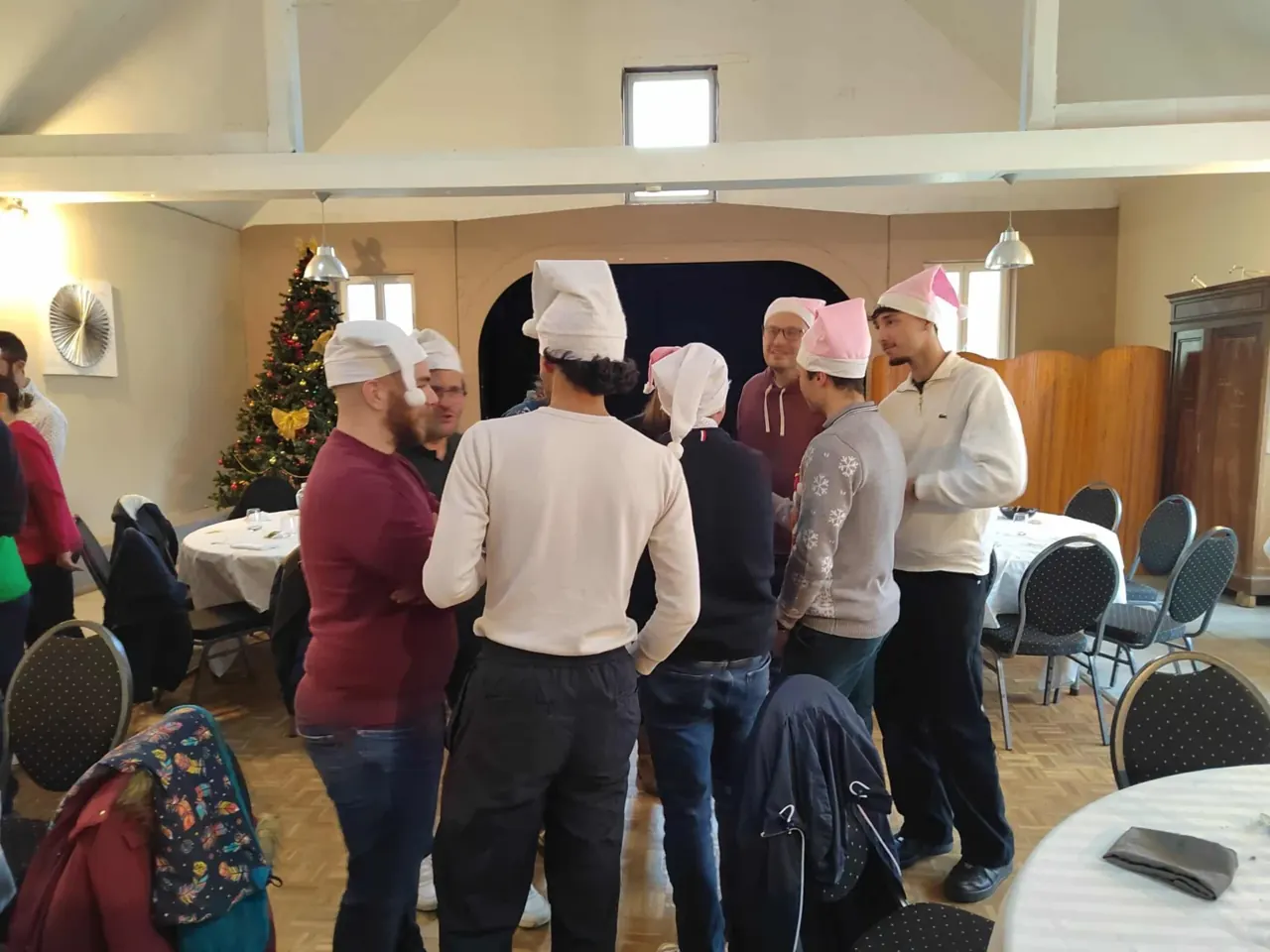 Joueurs en bonnets de Noël réunis près d'un sapin décoré