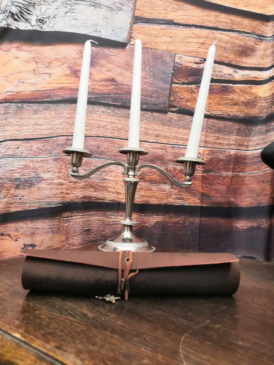 Chandelier et parchemin roulé sur une table en bois