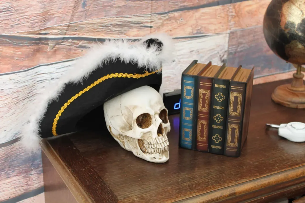 Tricorne, crâne et vieux livres posés sur un bureau