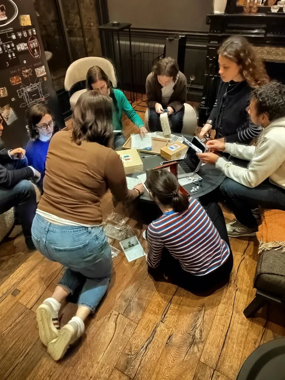 Joueuses assises par terre autour d'une table basse couverte d'indices