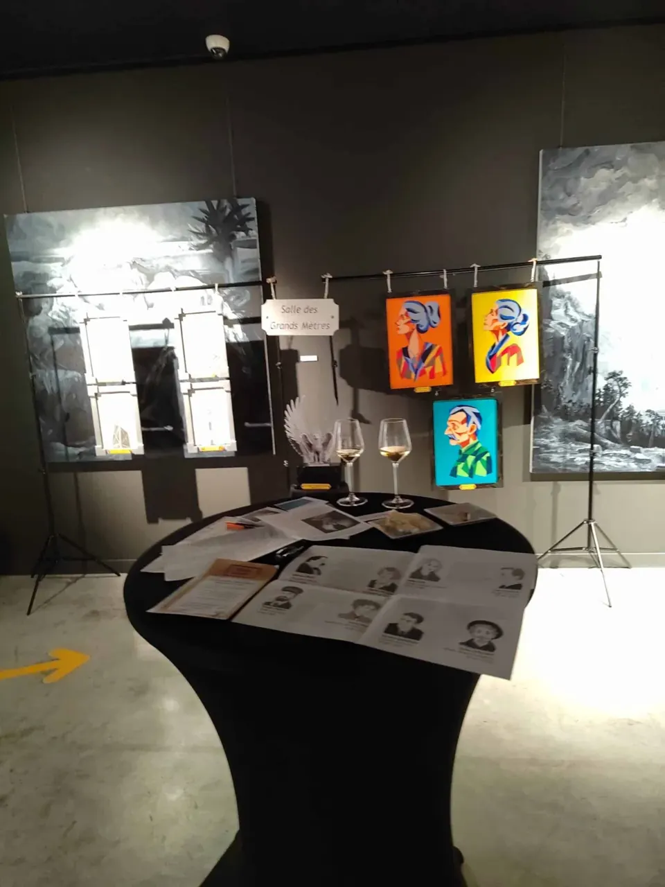 Tableaux colorés suspendus et indices étalés sur une table haute